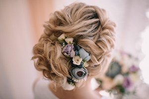 Blonde bride with wavy bun hairstyle with dried flowers